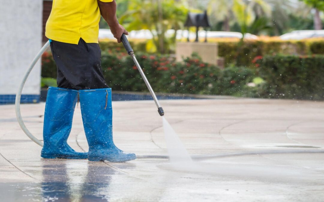 man wearing boots while holding power washer deepcleaning concrete floors